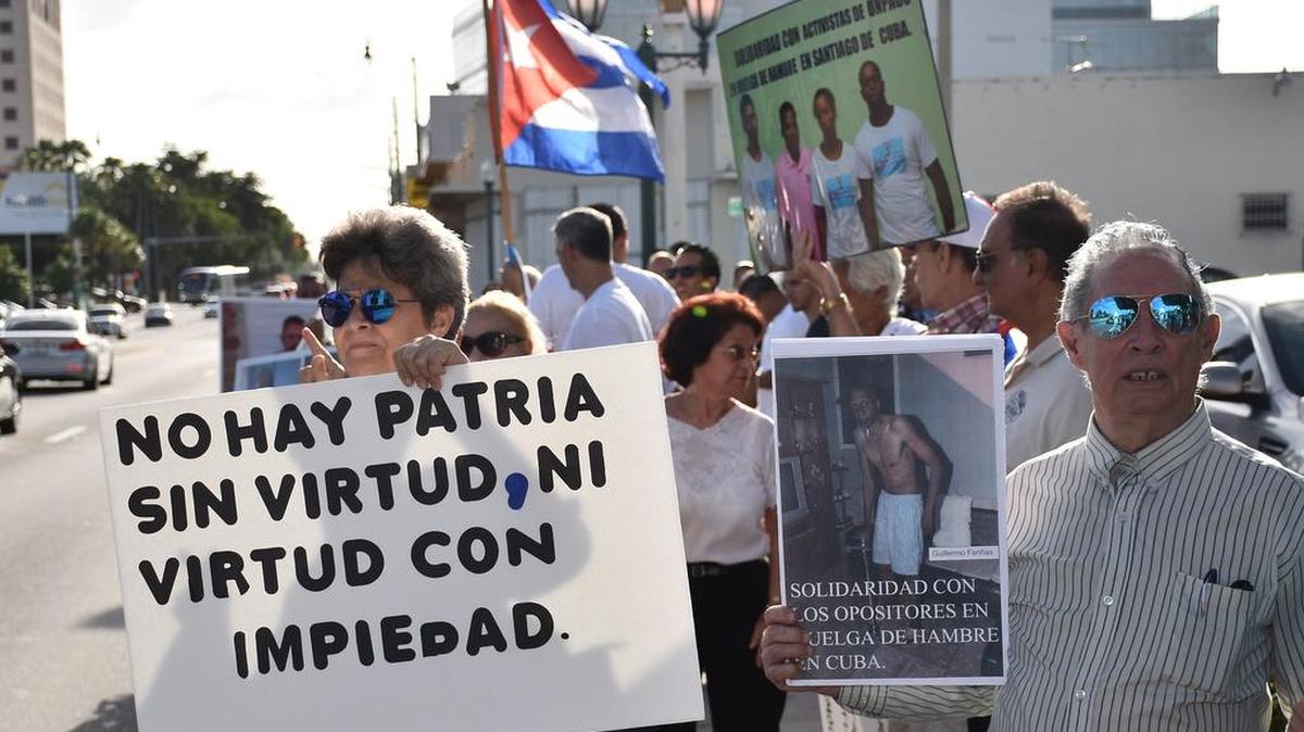 Varios cubanos sostienen carteles con fotos de Fariñas y banderas cubanas durante una vigilia realizada el miércoles 27 de julio 2016, frente al Restaurante Versailles en Miami, Florida.