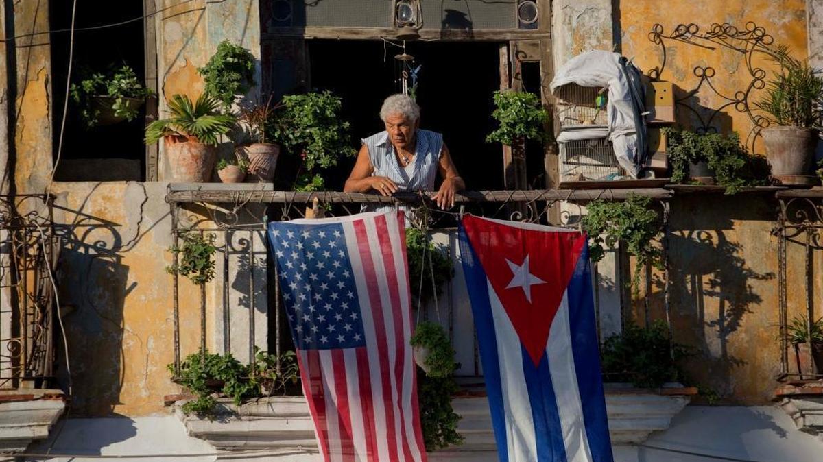 En esta foto de archivo del 19 de diciembre del 2014, dos días después del anuncio conjunto realizado por Barack Obama y Raúl Castro sobre el restablecimiento de relaciones diplomáticas, Javier Yanez está en su balcón decorado con las banderas de Estados Unidos y Cuba, en un edificio de La Habana Vieja.