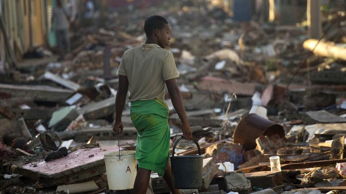 Un joven camina por una calle llena de los escombros que dejó el huracán Matthew en Baracoa.