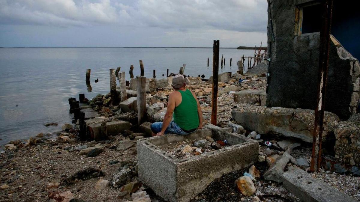 Un hombre mira al mar sentado en las ruinas de un restaurant destruido por el huracán Irma en Isabela de Sagua, Cuba.