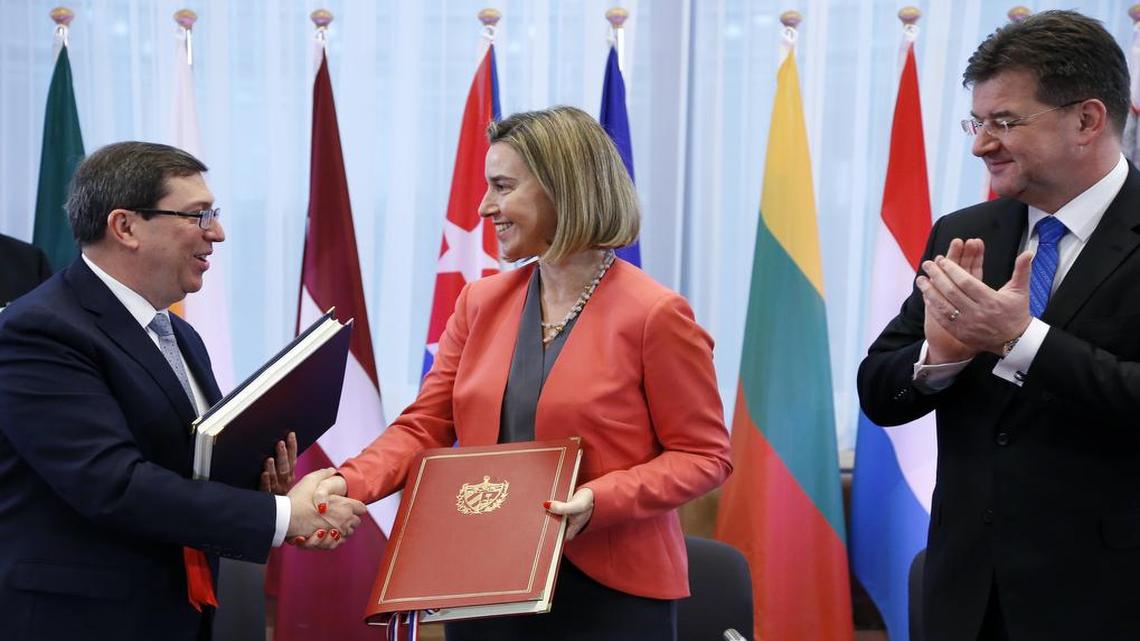 El canciller cubano, Bruno Rodríguez, estrecha la mano del alta representante de la Unión Europea, Federica Mogherini, tras la firma del acuerdo de cooperación en Bruselas. A la derecha, el canciller eslovaco Miroslav Lajcak.