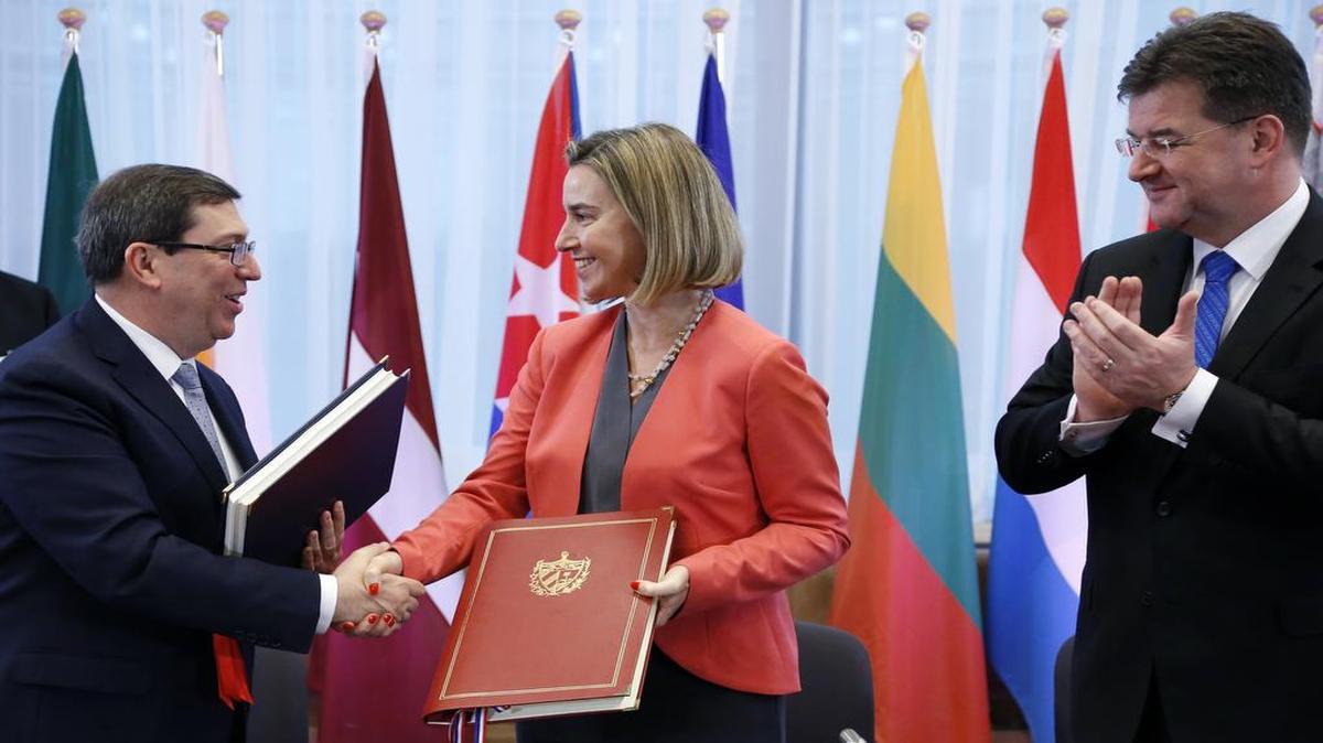 El canciller cubano, Bruno Rodríguez, estrecha la mano del alta representante de la Unión Europea, Federica Mogherini, tras la firma del acuerdo de cooperación en Bruselas. A la derecha, el canciller eslovaco Miroslav Lajcak.