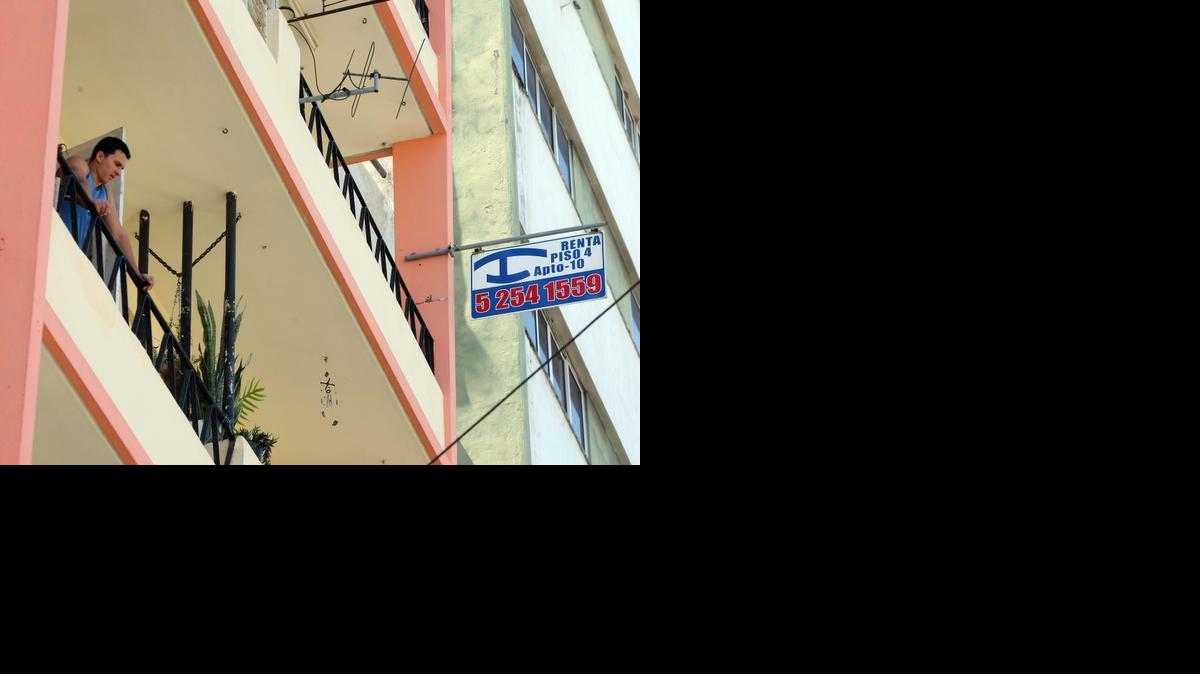 
Un joven se asoma a su balcón el jueves en La Habana junto a un cartel de renta de habitaciones. El portal de alquiler de viviendas particulares Airbnb anunció que ha ampliado su mercado a Cuba.


