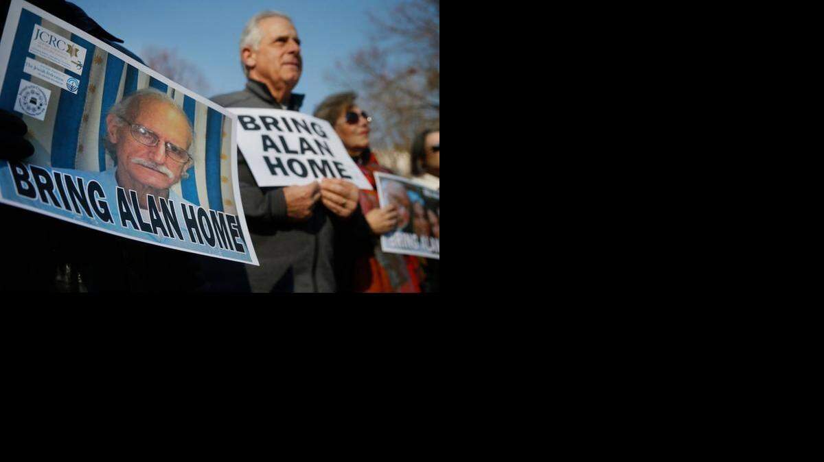 En esta foto del 3 de diciembre de 2013, partidarios de Alan Gross (cuyo rostro se muestra en un poster a la izquierda) conmemoran el cuarto aniversario de su arresto en Cuba con una protesta en el Parque Lafayette Park, frente a la Casa Blanca en Washington DC.  
