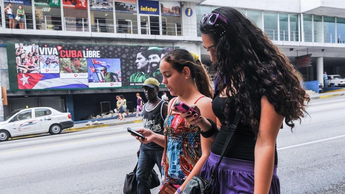 Un par de muchachas cubanas revisan sus celulares en una calle de La Habana en junio del 2015.