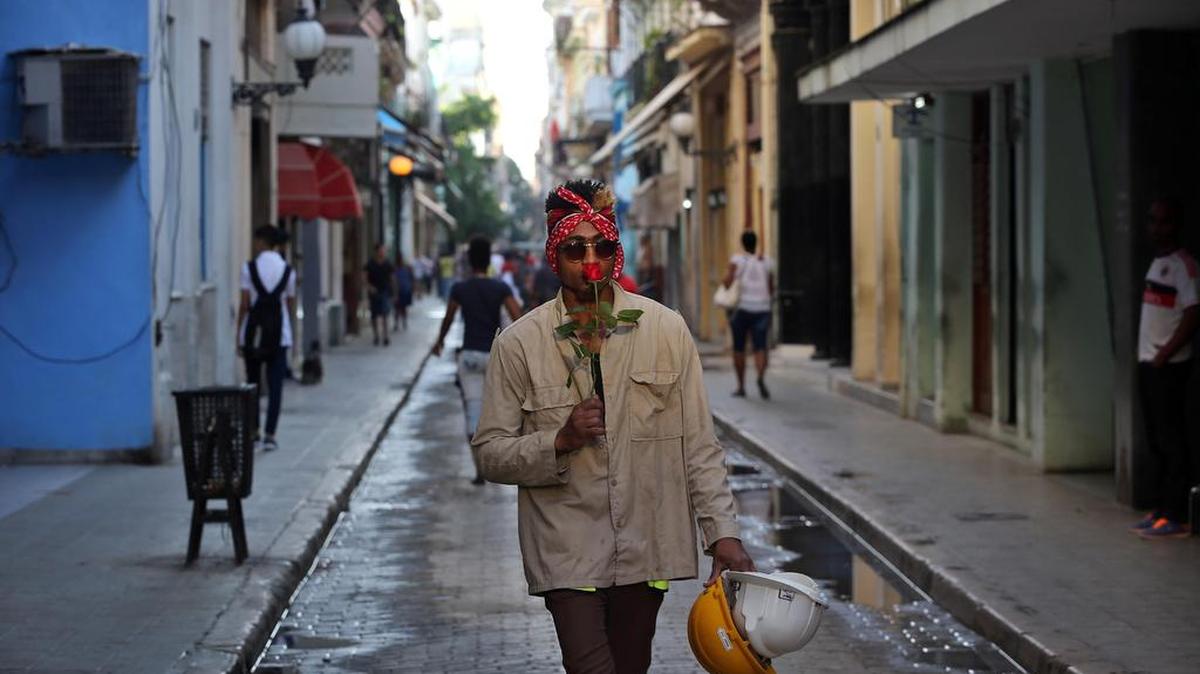 Un obrero camina oliendo una rosa, en La Habana (Cuba) hoy, martes 25 de octubre de 2016, un día antes de que se someta a votación en la Asamblea General de la ONU la propuesta de resolución de Cuba para que la comunidad internacional se sume a su reclamo de levantar el embargo a la isla, en vigor desde 1962.
