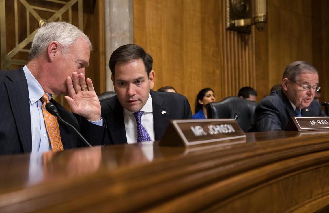 El senador Marco Rubio (centro), republicano por Florida, habla con el senador Ron Johnson (izquierda), republicano por Wisconsin, mientras el senador Bob Menéndez (derecha), demócrata por Nueva Jersey, habla en una reunión de una subcomisión de la Comisión de Relaciones Exteriores del Senado. Foto archivo.