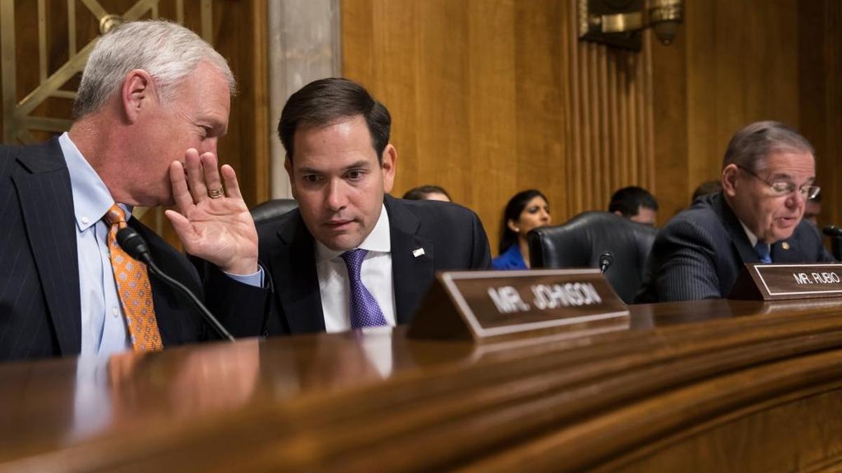 El senador Marco Rubio (centro), republicano por Florida, habla con el senador Ron Johnson (izquierda), republicano por Wisconsin, mientras el senador Bob Menéndez (derecha), demócrata por Nueva Jersey, habla en una reunión de una subcomisión de la Comisión de Relaciones Exteriores del Senado. Foto archivo.