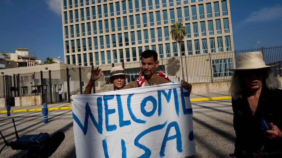 Dos personas sostienen un letrero que da la bienvenida a los norteamericanos frente a la Embajada de EEUU en La Habana, el 20 de julio.
