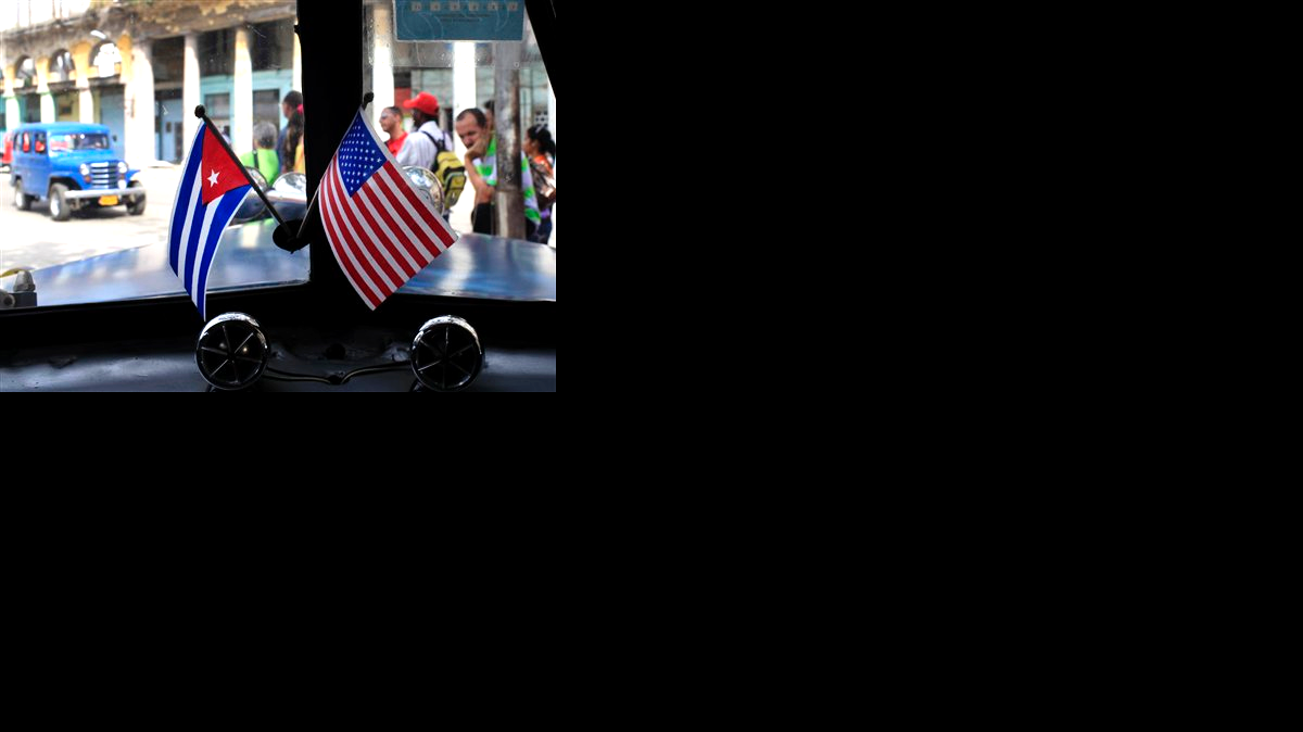 Fotografía de archivo del 22 de marzo de 2013 de dos pequeñas banderas de Cuba y Estados Unidos sobre el tablero de instrumentos de un automóvil en La Habana, Cuba.