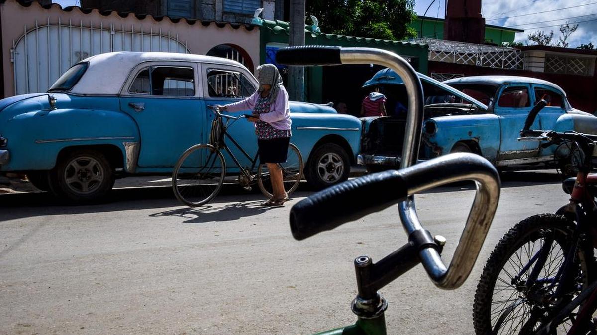 Una anciana cubana camina con su bicicleta en Cárdenas, ciudad situada a 130 kilómetros al este de La Habana, el 30 de agosto de 2017.