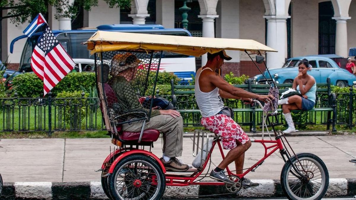 Un bicitaxi con una bandera de EEUU transporta a unos turistas el 16 de enero, en La Habana.