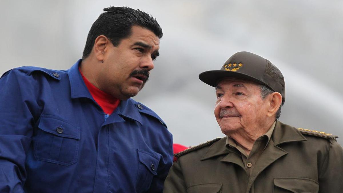 
Los gobernantes de Cuba y Venezuela, Raúl Castro (d) y Nicolás Maduro (i), respectivamente, conversan, el viernes 1 de mayo de 2015, en La Habana (Cuba), durante el desfile por el día de los trabajadores.  
