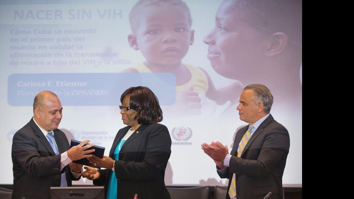 
La directora de la Organización Mundial de la Salud (OMS), Carissa Etienne, entrega el martes un certificación al ministro de Salud Pública de Cuba, Roberto Tomás Morales Ojeda (izq.), durante el anuncio de que ese país se convirtió en el primero del mundo en eliminar la transmisión del virus del sida y de la sífilis de madre a hijo.
