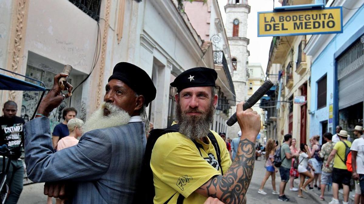 Fotografía del lunes 29 de enero de 2018, muestra a un turista mientras posa junto a un cubano, en La Habana (Cuba).