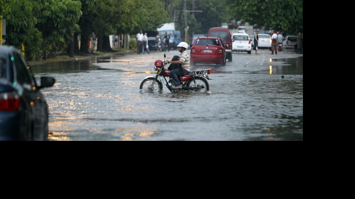 
 Un hombre conduce una motocicleta por una calle inundada el miércoles 29 de abril de 2015, en La Habana (Cuba). 
