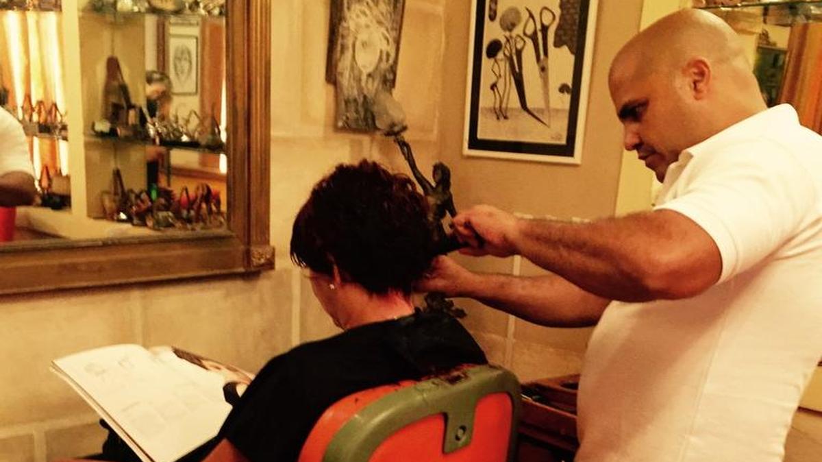 Gilberto “Papito” Valladares atiende a un cliente en su barbería en La Habana Vieja.
