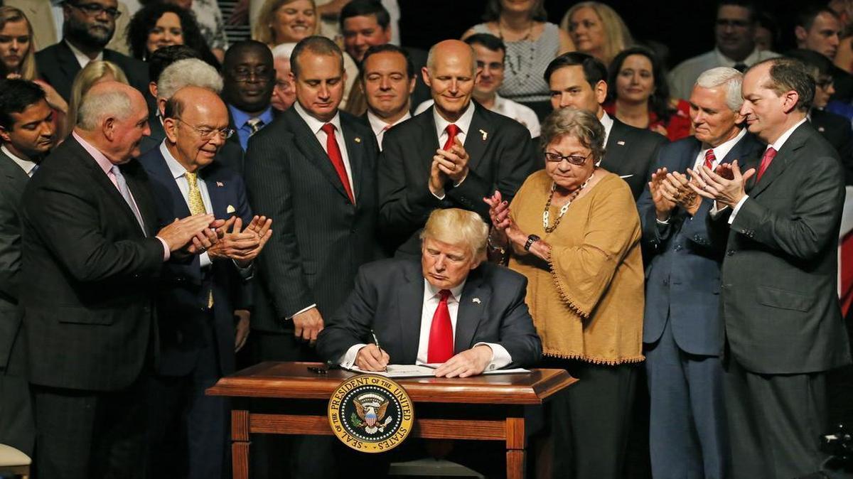 El presidente Donald Trump firma la orden ejecutiva con las nuevas directivas de la política hacia Cuba, en el Teatro Manuel Artime de Miami el viernes 16 de junio del 2017.