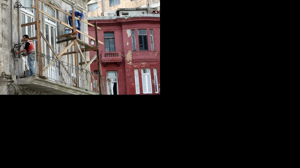 
Dos hombres reparan el exterior de una vivienda hoy, lunes 1 de diciembre de 2014, en La Habana (Cuba).
