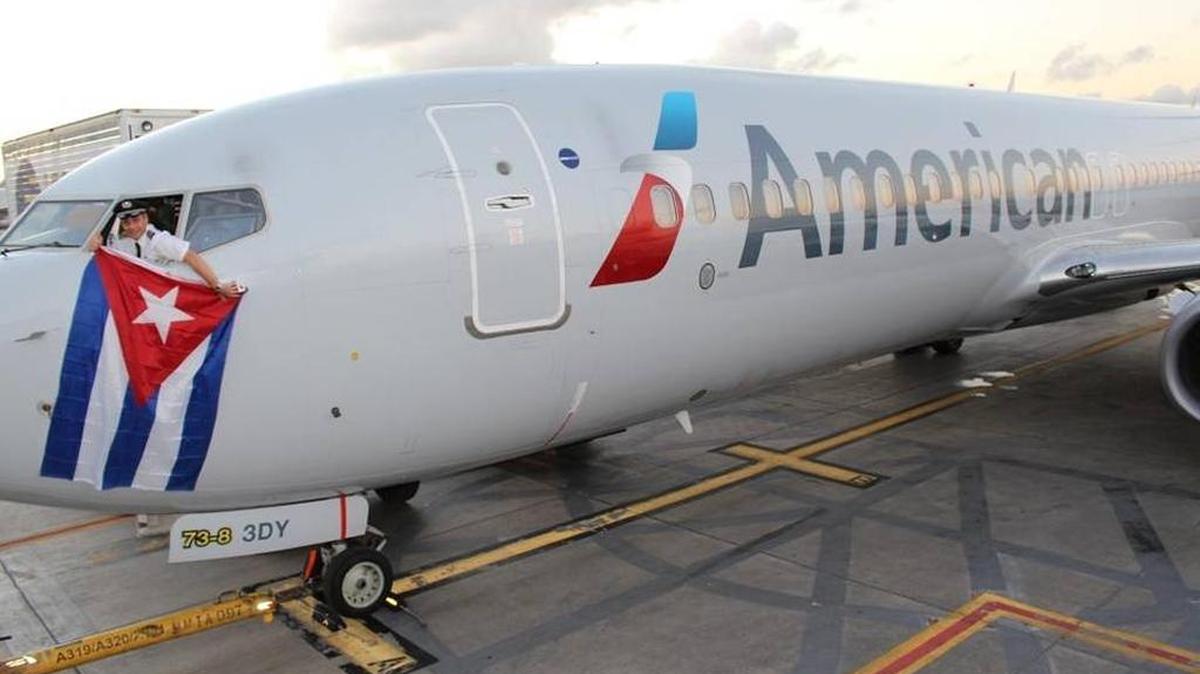 Kevin Mase, piloto de American Airlines, muestra una bandera cubana desde un Boeing 737 de la aerolínea el 16 de diciembre del 2015, el día que Estados Unidos y Cuba llegaron a un acuerdo para reanudar los vuelos comerciales regulares entre los dos países.