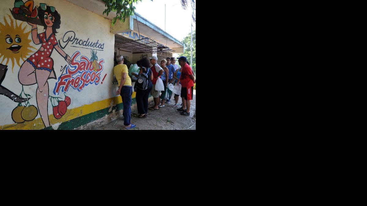 
Varias personas compran vegetales en el punto de venta de un huerto urbano el 19 de agosto de 2011, en La Habana. El gobierno cubano anunció el domingo 28 de diciembre de 2014, una inversión de $100 millones para impulsar el cultivo de hortalizas y frutas.
