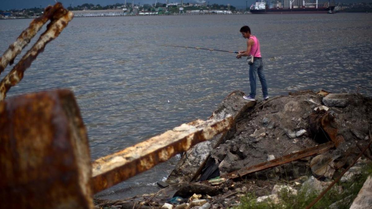 Un hombre pesca en una zona llena de desechos en la Bahía de La Habana al otro lado de la refinería de petróleo, en una imagen de septiembre del 2013.