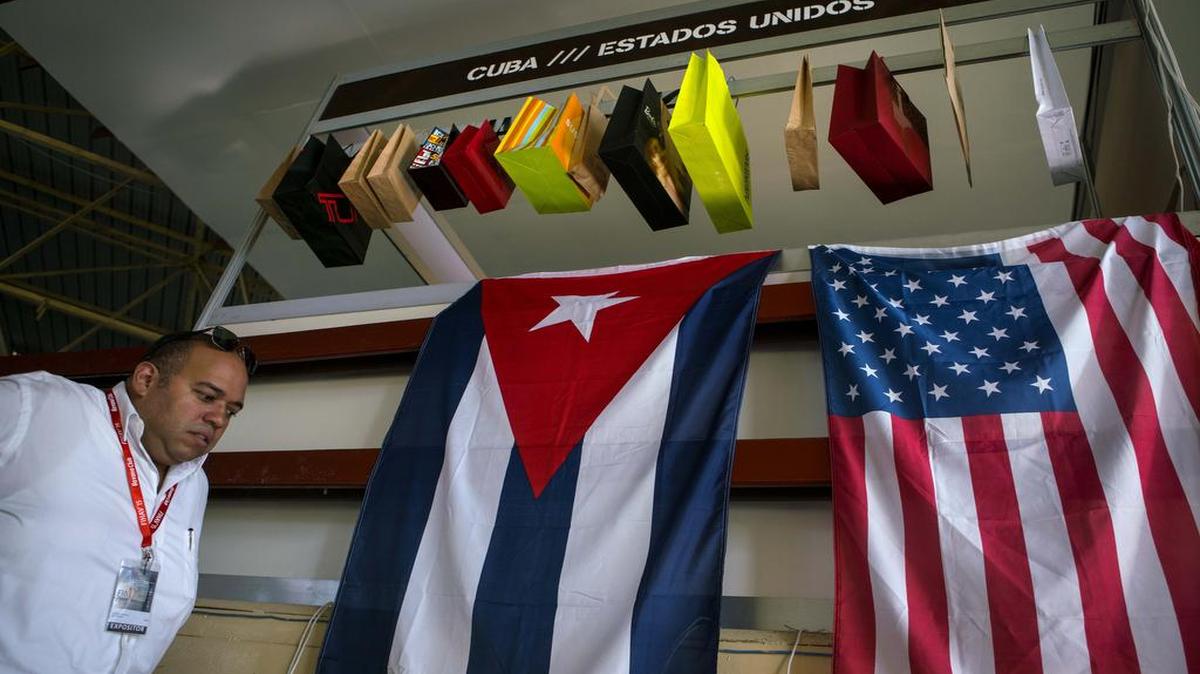 Un hombre camina junto a las banderas de Cuba y Estados Unidos durante la Feria Internacional de La Habana el 2 de noviembre 2015.