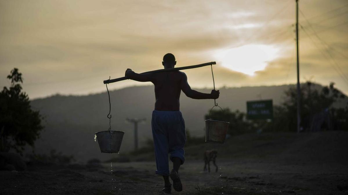 Un hombre carga agua cerca de Santiago de Cuba. Foto de archivo.