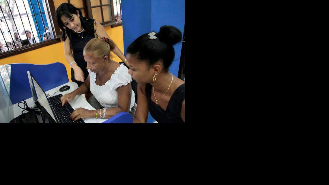 
Una empleada de ETECSA (Empresa de Telecomunicaciones de Cuba S.A.) ayuda a unos clientes en un centro de internet en La Habana, el 4 de junio. Foto de archivo.
