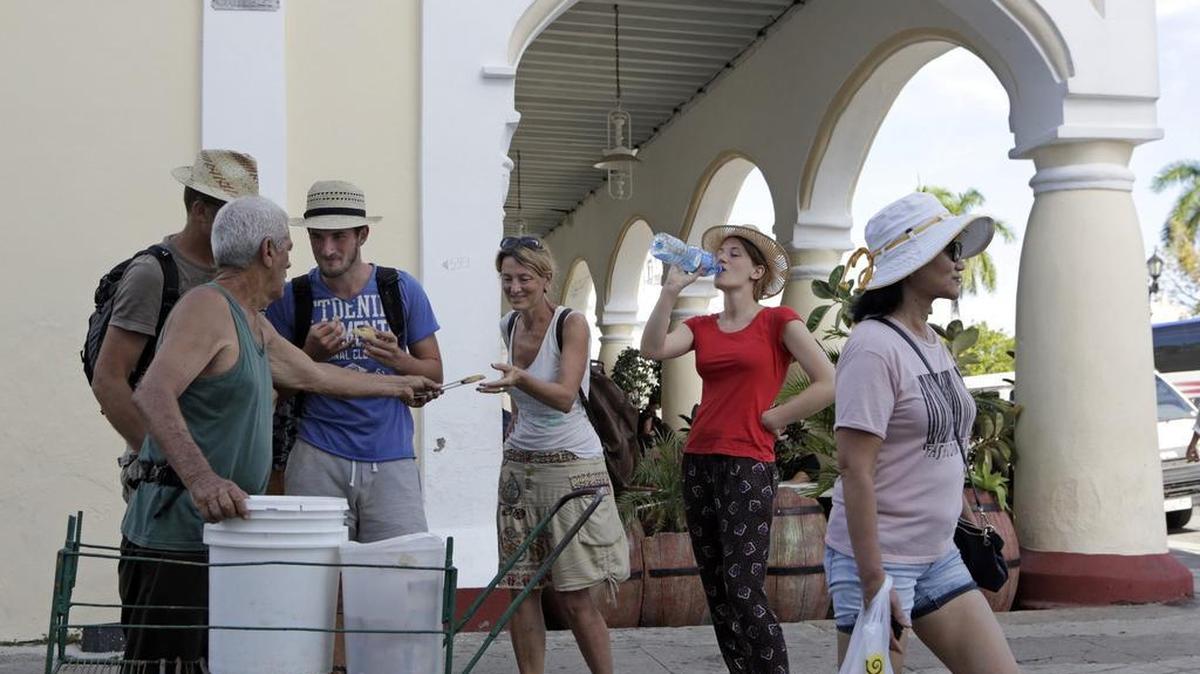 Un cuentapropista vende polvorones a los turistas junto al teatro en Cienfuegos