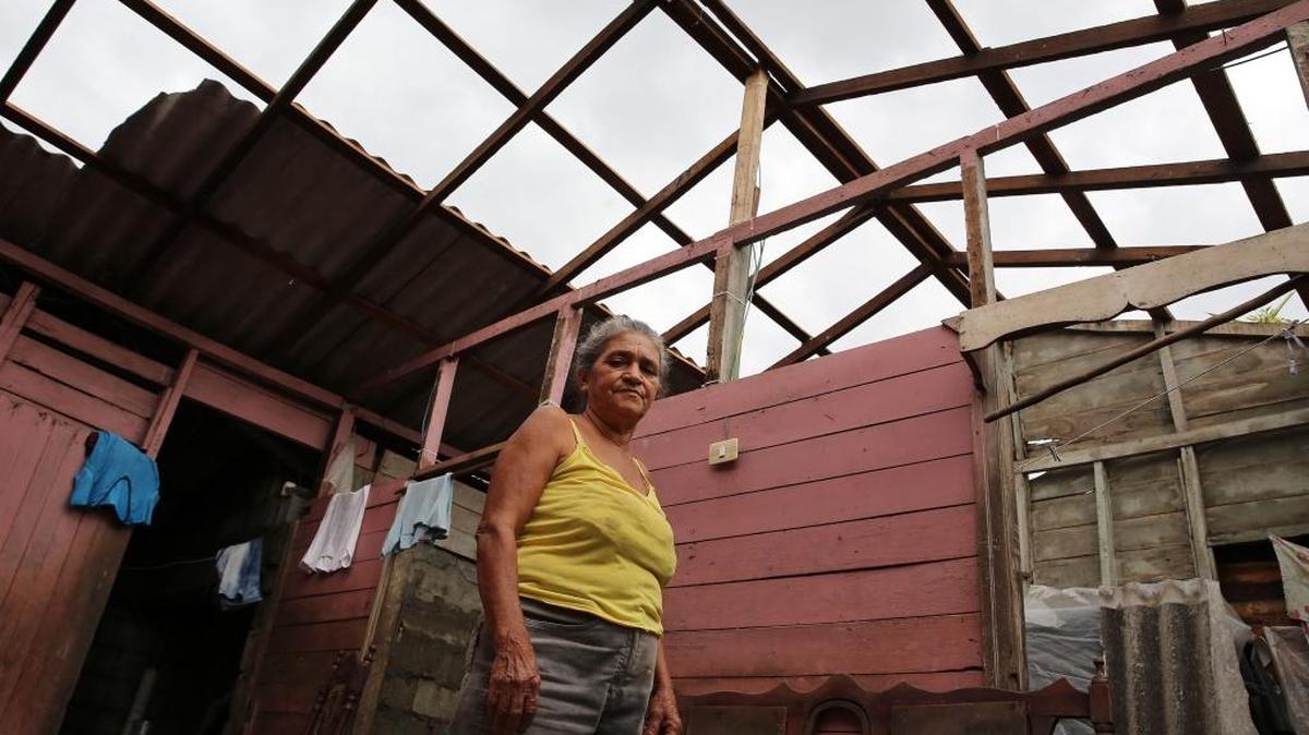 Una mujer en la ciudad de Baracoa en la sala de lo que quedó de su vivienda tras el azote del huracán Matthew por el extremo más oriental de Cuba.