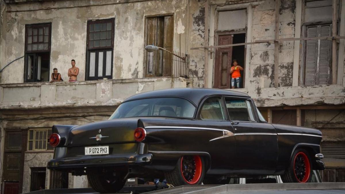 Cubanos en los balcones observan a uno de los autos antiguos utilizados durante la filmación de Fast & Furious 8 en La Habana.