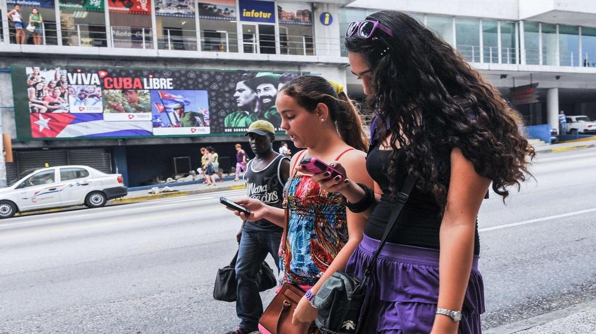 Dos jóvenes cubanas usan sus teléfonos celulares en una calle de La Habana el 19 de junio del 2015.