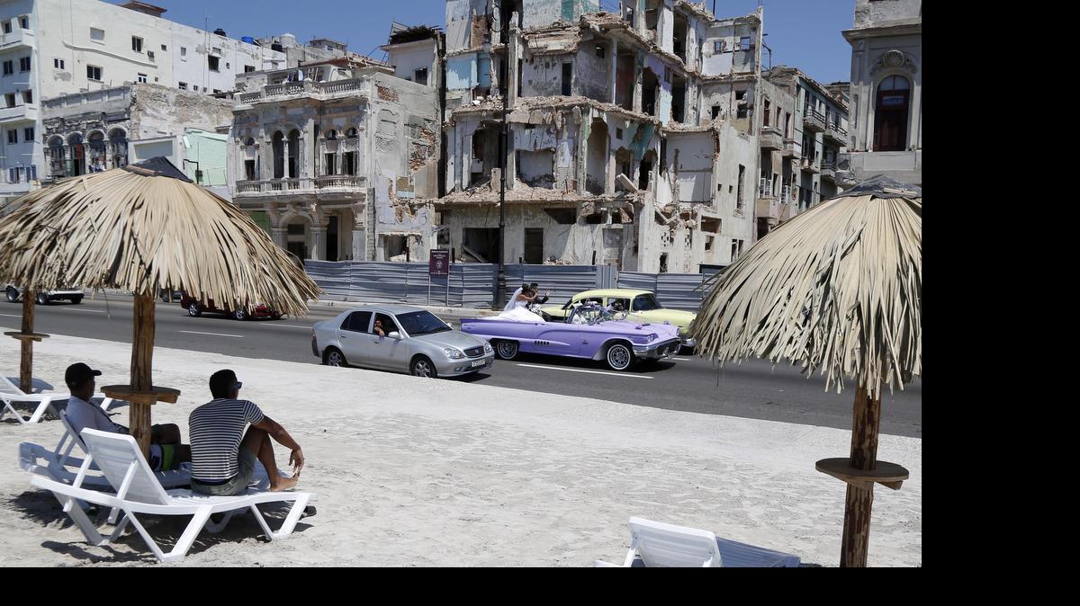
Las personas se sientan en las sillas de una playa artificial en el Malecón habanero, parte de una intervención del artista visual Arlés del Río Flores, en la exhibición colectiva ‘Detrás del Muro/Behind The Wall’.
