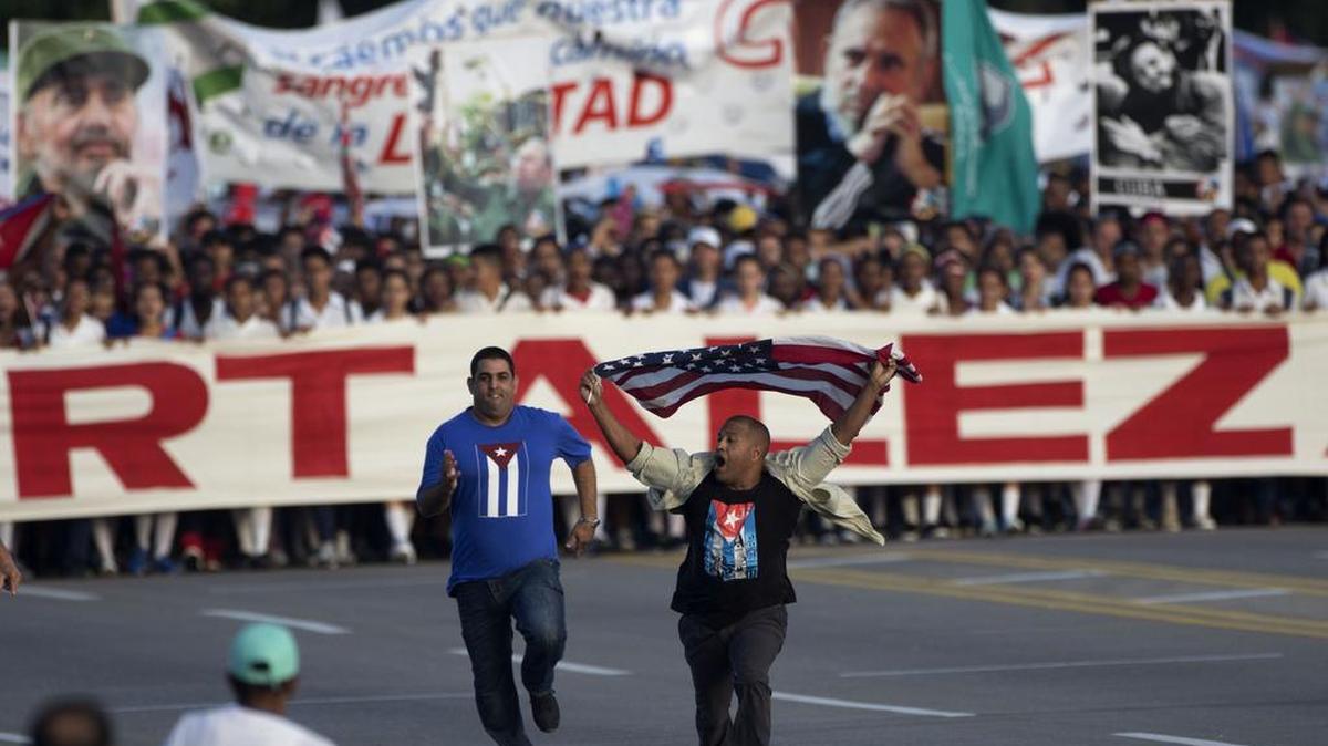 Un agente de seguridad persigue al opositor Daniel Llorente cuando este protestaba con una bandera de EEUU durante la marcha del Día del Trabajo en La Habana, el 1 de mayo de 2017.