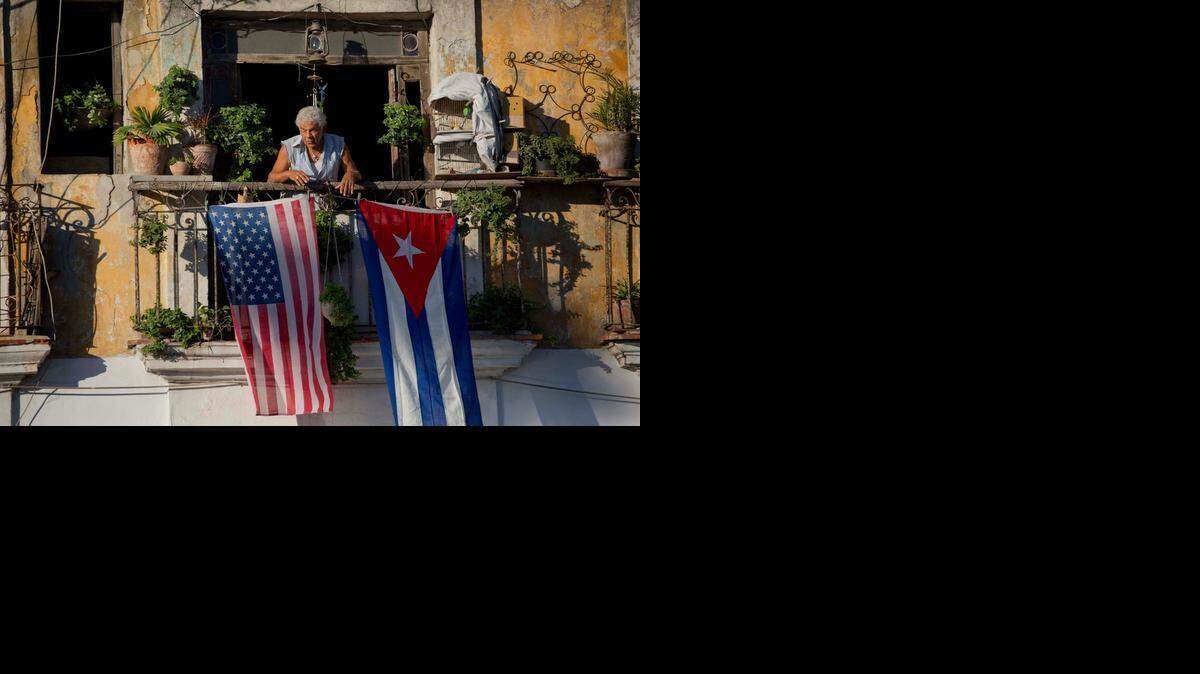 
Javier Yánez cuelga de su balcón las banderas de Estados Unidos y Cuba en diciembre pasado.
