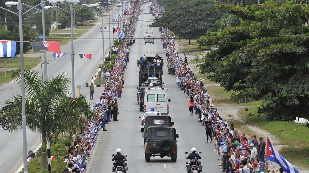 Personas se acercan a la carretera para rendir tributo a las cenizas del ex gobernante cubano Fidel Castro, que son transportadas de La Habana a su destino final en Santiago de Cuba. En esta fotografía del 1 de diciembre, la caravana pasaba por Sancti Spiritus.