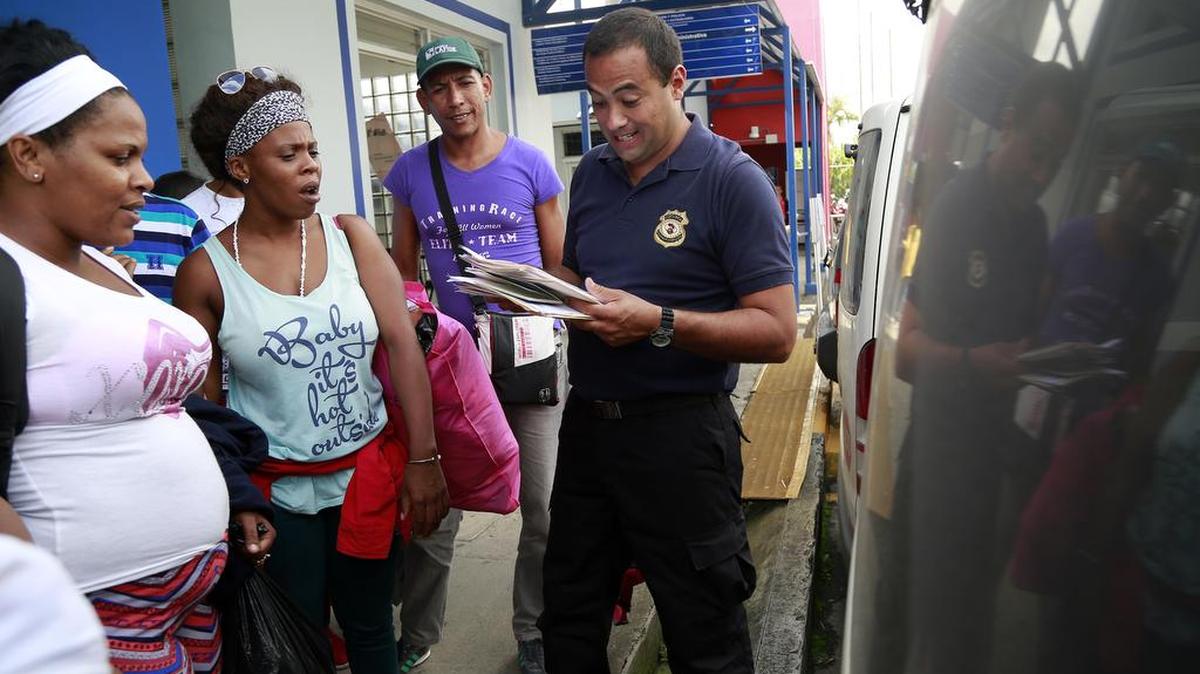 Migrantes cubanos son detenidos por un agente de inmigración en Costa Rica antes de abordar un autobús hasta la frontera con Nicaragua.
