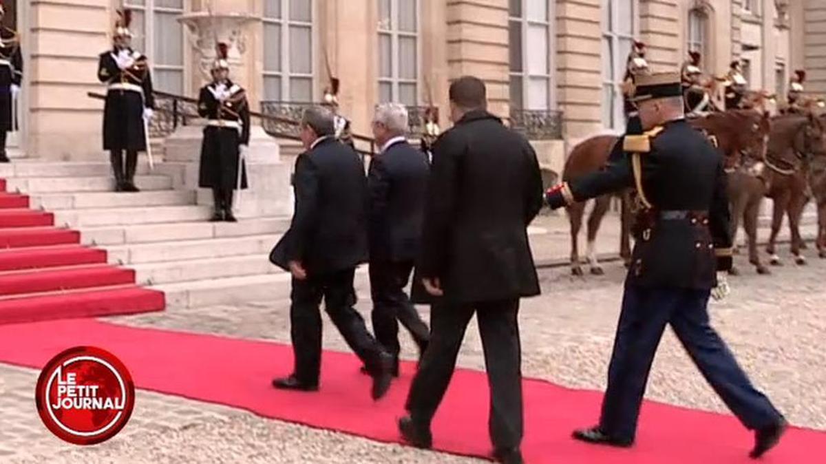 Un militar fránces trata de evitar que el guardaespaldas de Raúl Castro interrumpa el protocolo de recibimiento por parte del presidente francés François Hollande.