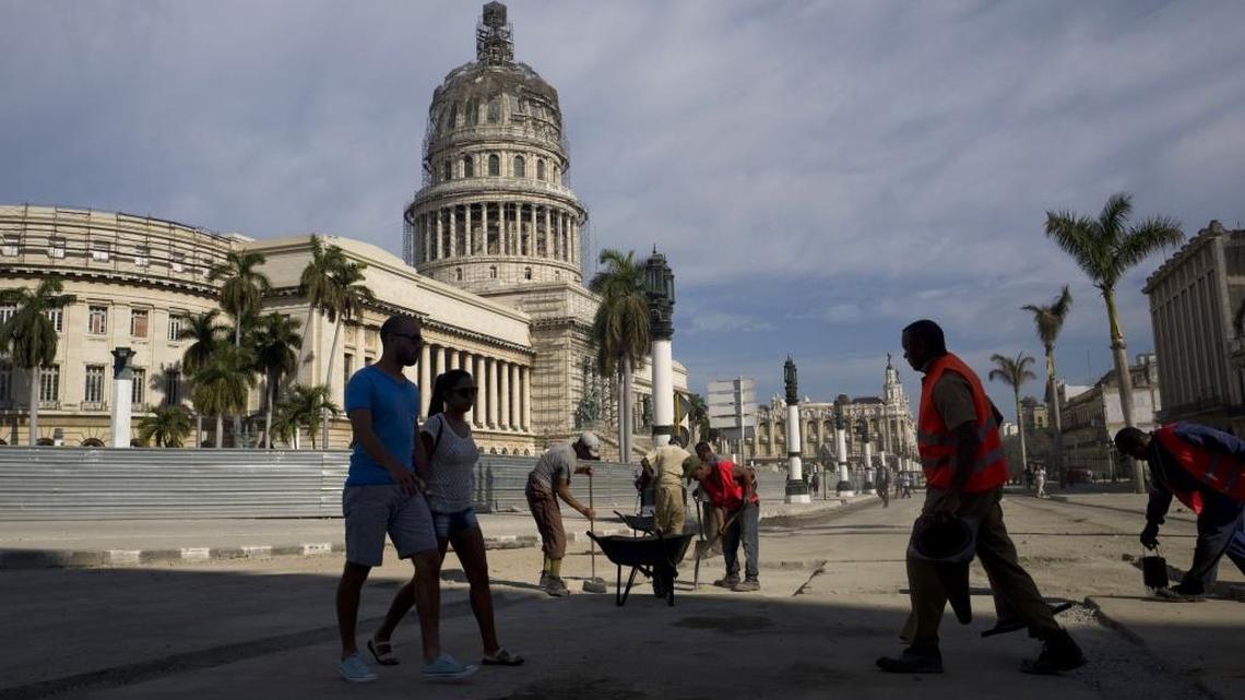 Trabajadores reparan la calle frente al edificio del Capitolio en La Habana.