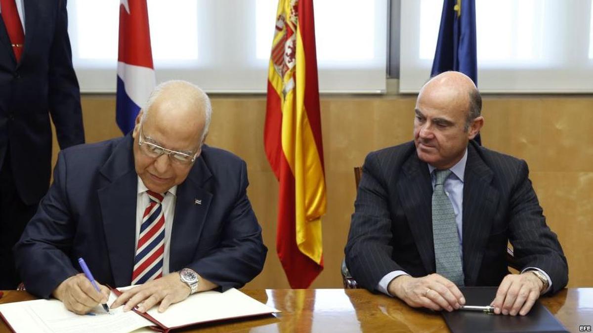 Luis de Guindos, ministro español de Economía y Competitividad, y el vicepresidente del Consejo de Ministros de Cuba, Ricardo Cabrisas Ruiz firmando los acuerdos de reestructuración de la deuda.