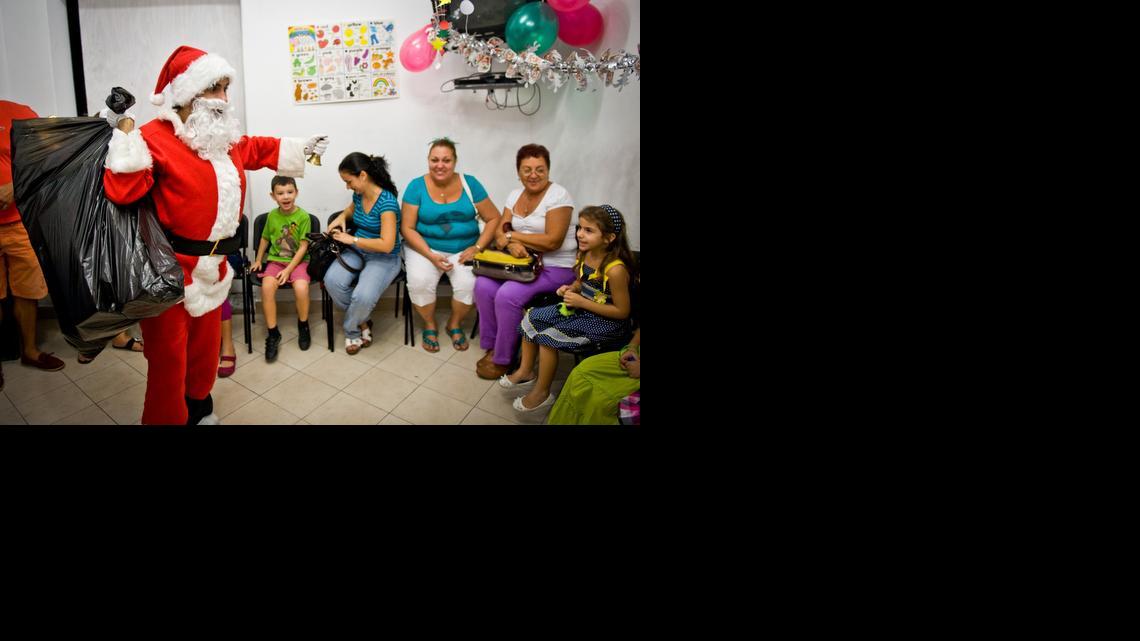 
En los barrios de la ciudad se organizan fiestas infantiles con un abrigado Santa Claus repartiendo obsequios en medio del calor tropical.
