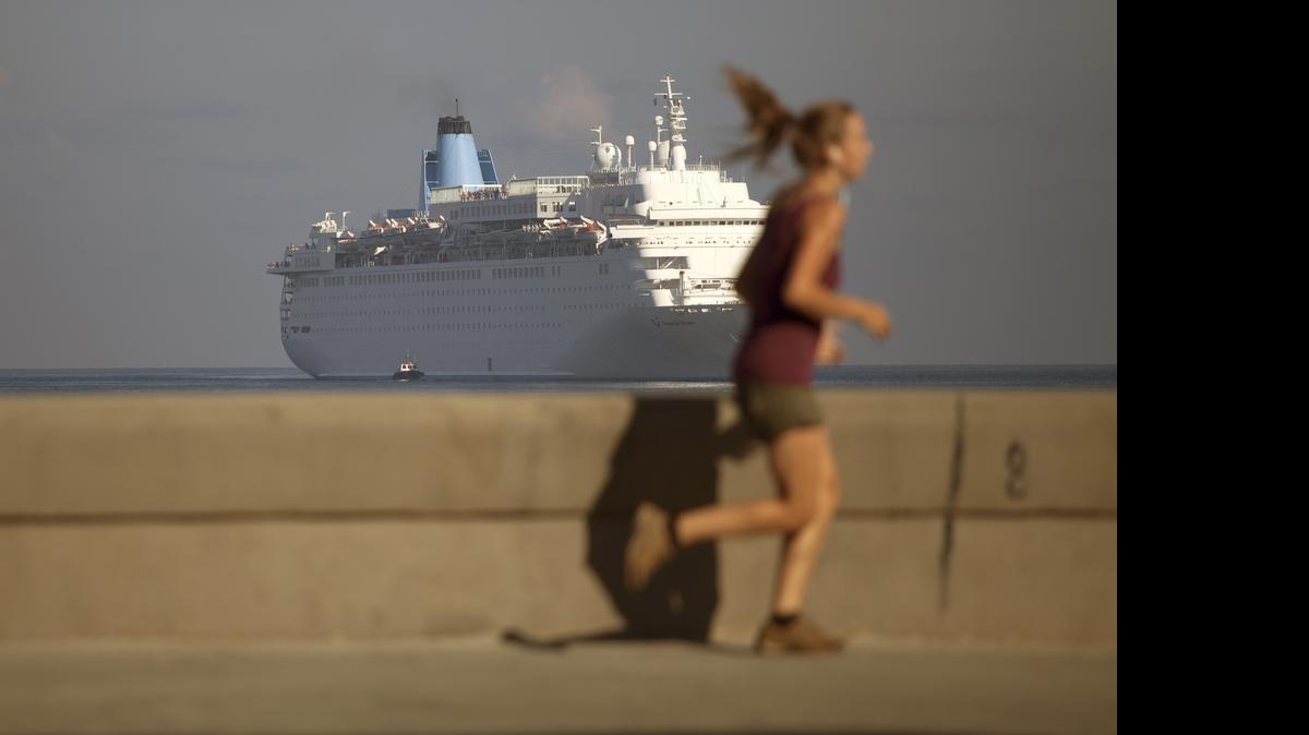 
Con un crucero de fondo, una mujer corre por el Malecón de La Habana. Los servicios de ferry con pasajeros hacia Cuba, autorizados esta semana por Washington, estimularán los viajes desde Estados Unidos.
