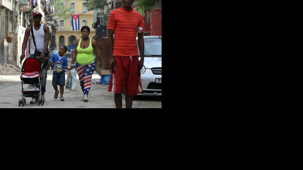 
Una mujer vestida con la bandera de Estados Unidos camina junto a su familia en una calle de La Habana (Cuba), hoy viernes 26 de diciembre de 2014. EFE/Alejandro Ernesto

