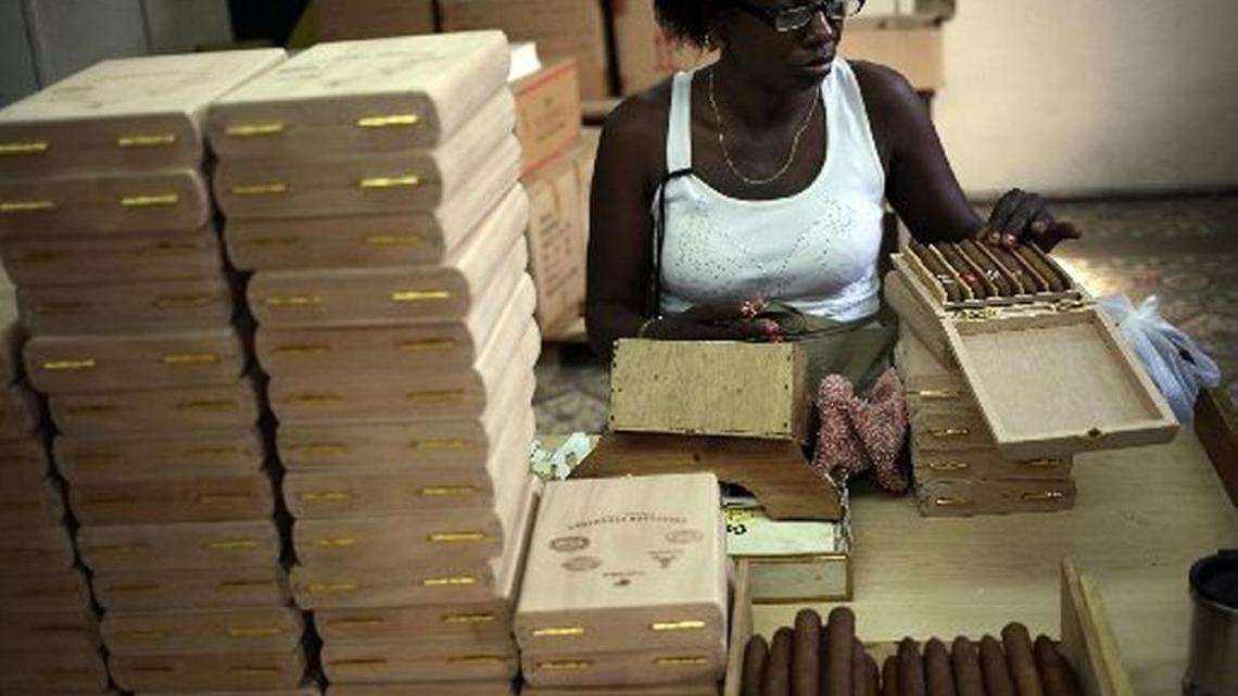 
Una mujer trabaja guardando tabacos en cajas en el 2014, en la fábrica de puros La Corona, en La Habana.
