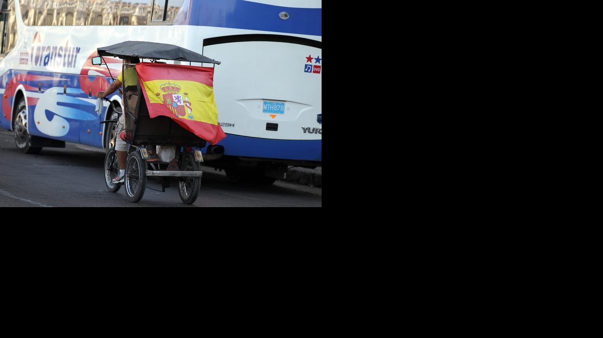 
Un bicitaxi circula con una bandera de España hoy, miércoles 15 de abril de 2015, en una calle de La Habana (Cuba). 

