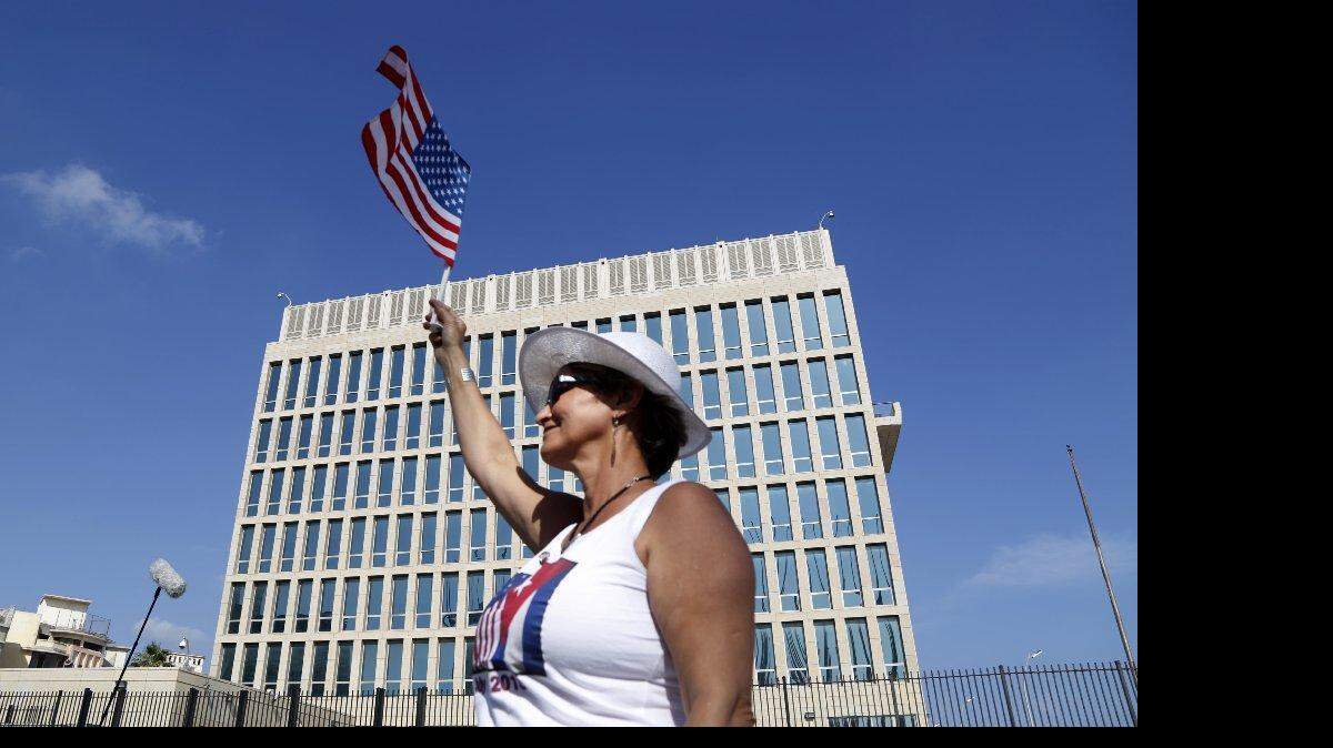 Una mujer ondea una bandera frente a la embajada de Estados Unidos en la Habana, Cuba el lunes 20 de julio.