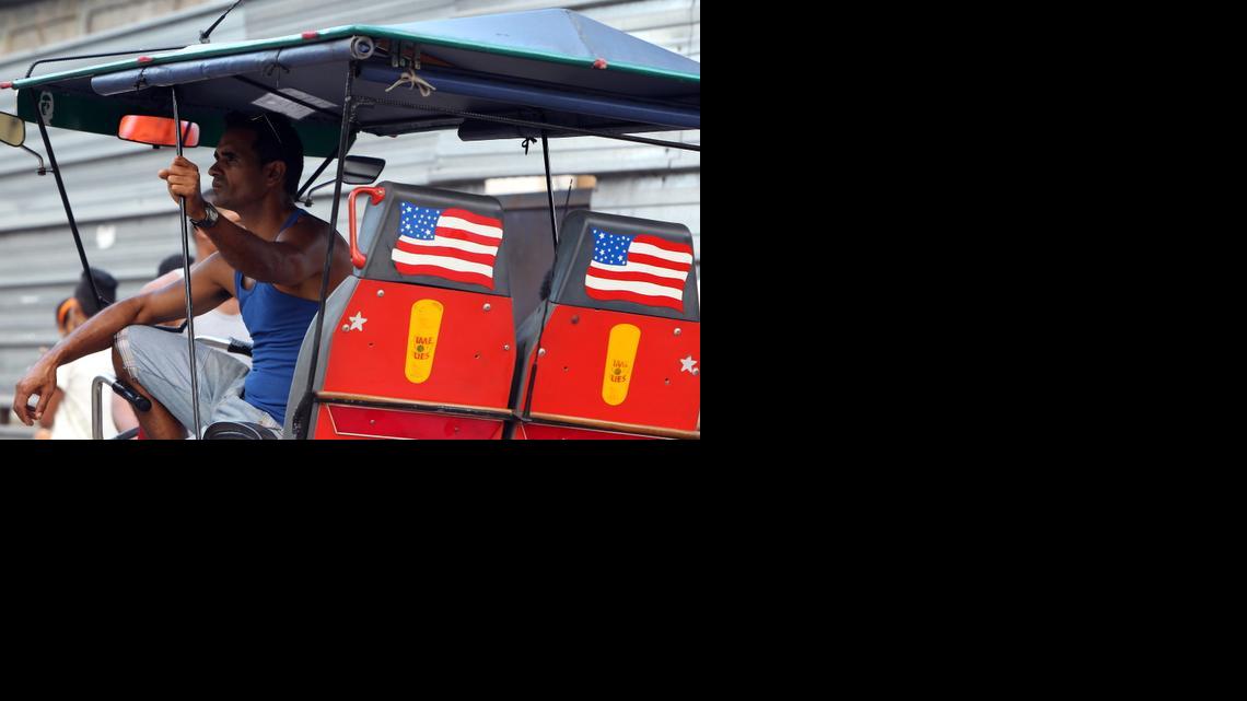 
Un bicitaxista espera clientes en un vehículo adornado con la bandera de los Estados Unidos camina el lunes 29 de diciembre de 2014, en una calle de La Habana (Cuba).
