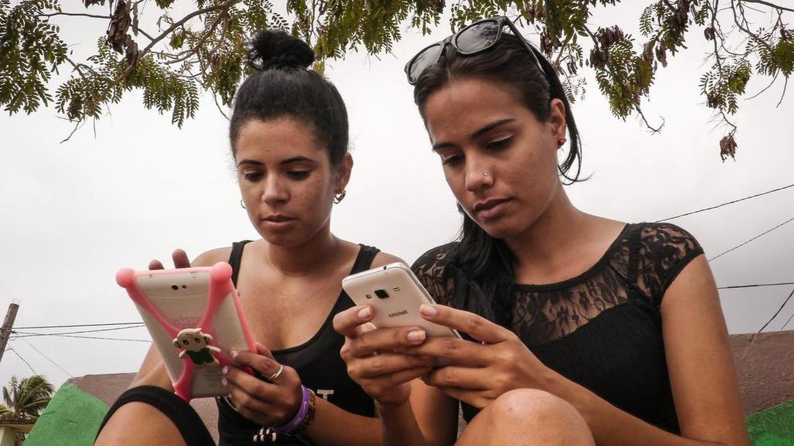 Jóvenes cubanas usan WIFI en sus teléfonos celulares en un parque de Gaspar, una pequeña ciudad de la provincia de Ciego de Avila, en el centro de Cuba, el 18 de abril de 2017.