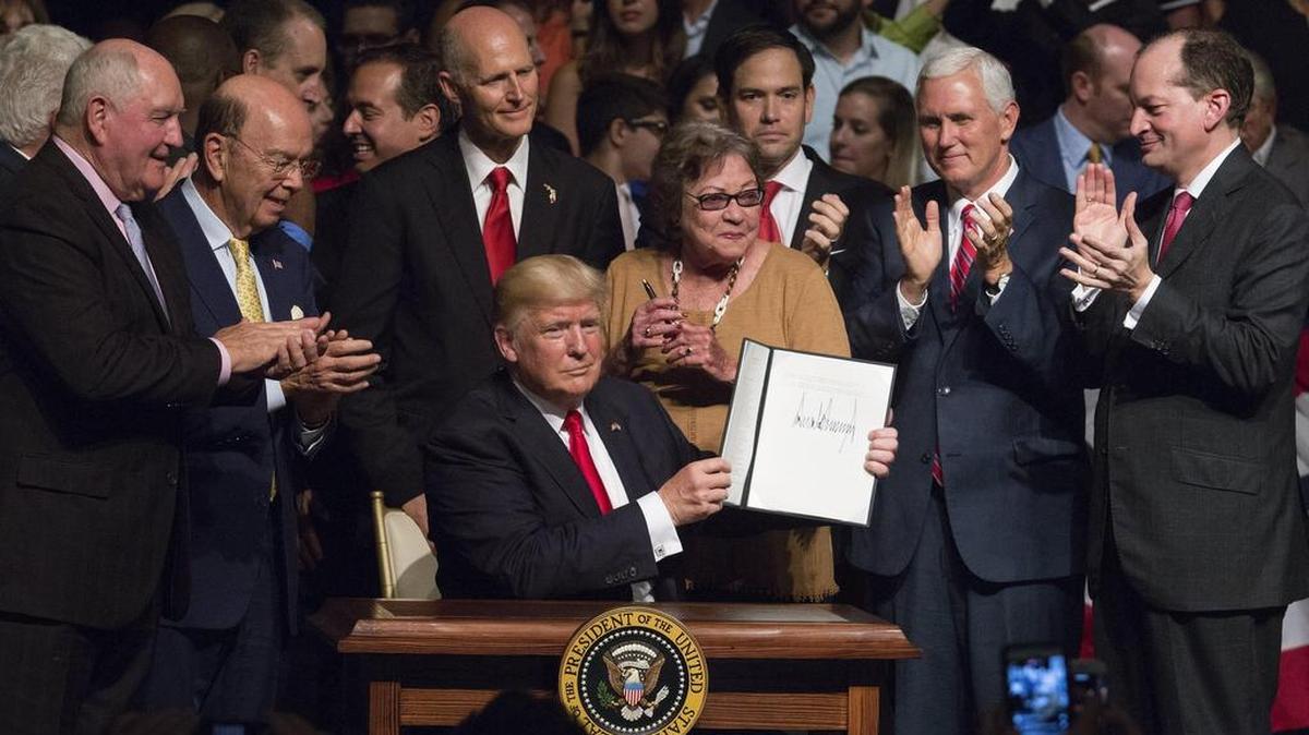 El presidente estadounidense, Donald J. Trump (c), muestra el memorando presidencial sobre la política con Cuba al finalizar su discurso en el teatro Manuel Artime de la Pequeña Habana, en Miami, el 16 de junio de 2017.